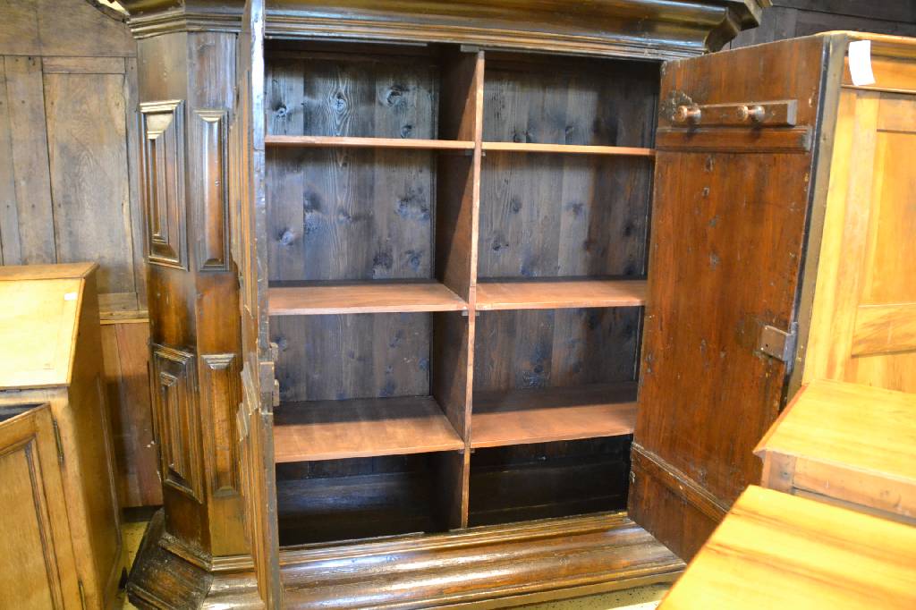 Detail a: Kissenschrank, um 1700, Fichte dunkel lasiert, 2-türig, reiche aufgesetzte Kassetten, innen m. 3 Bretter rechts und links, Kopf getreppt, ohne ...