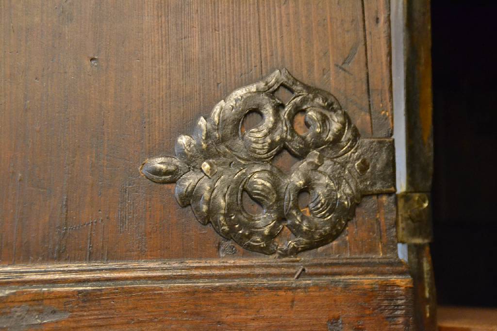 Detail b: Kissenschrank, um 1700, Fichte dunkel lasiert, 2-türig, reiche aufgesetzte Kassetten, innen m. 3 Bretter rechts und links, Kopf getreppt, ohne ...