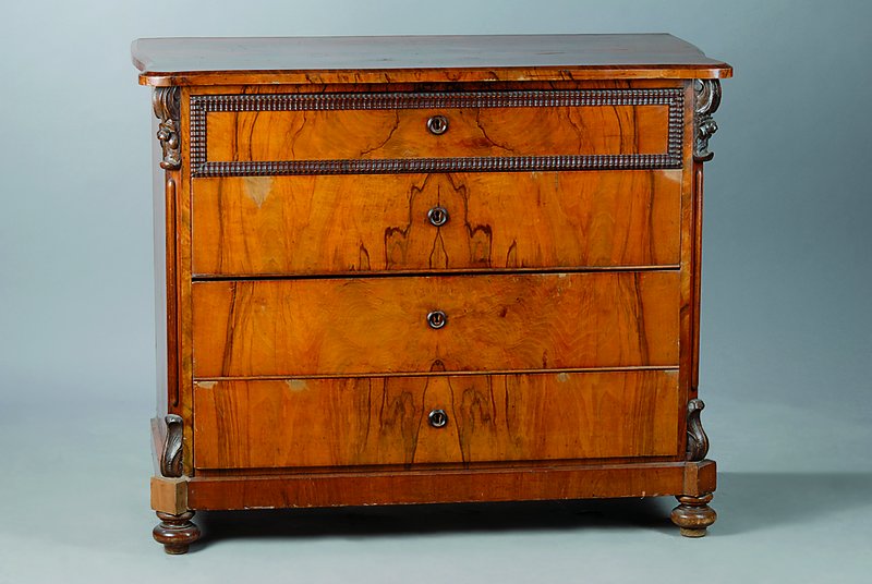 Kommode, um 1840/50, Nußbaum/Wurzelnußfurnier gesp. verlegt, 4 -schübig, abgerundete Ecken, sparsam aufgesetzte Akanthusblattschnitzereien, l. ...