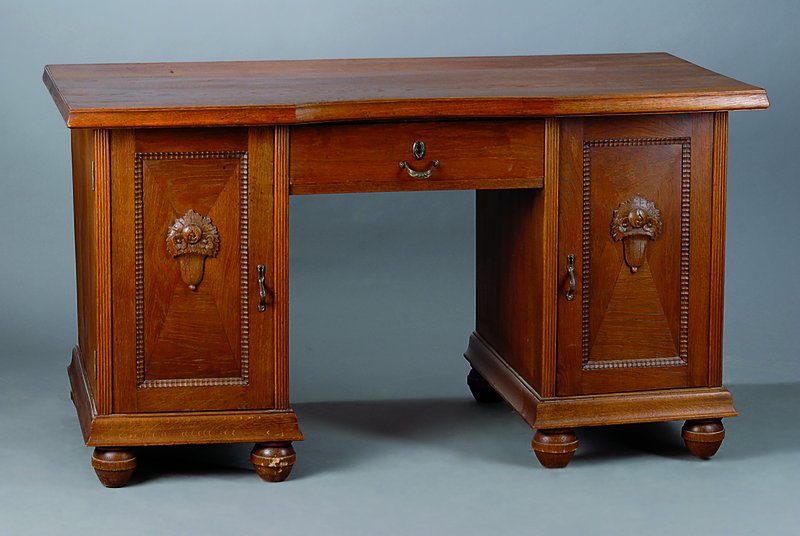Schreibtisch, um 1910/15, Eiche massiv, 2 -türig, 1-schübig, Türeninlets m. aufges. Blütenschnitzerei, Perlleistenverz., Füße m. starken Reste ...