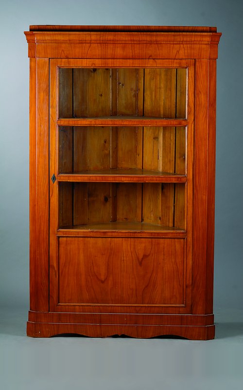 Eckschrank, Biedermeierstil, unter Verwendung alter Teile, Kirschbaumfurnier, 1 -türig, verglast u. versprosst, abgeflachte Ecken, l. schwundrissig, ...