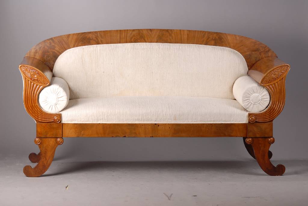 Biedermeiersofa, norddeutsch, um 1825, Mahagonifurnier, vielfach gesp. verlegt, Polsterung intakt, Bezug zu erneuern, Wangen m. reich geschnitzten ...
