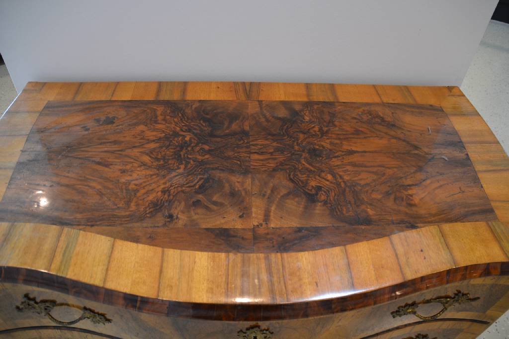 Detail d: Kommode, mitteldeutsch, um 1750, Nußbaum/Wurzelnußfurnier, Front geschweift, 3 -schübig, reich verzierte Bronzebeschläge, Reste alten ...