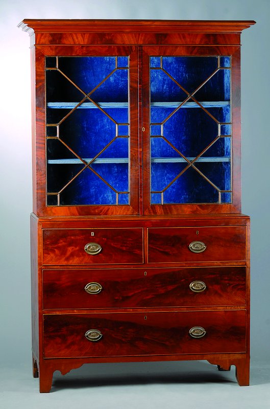 Bücherschrank, England, um 1810, Mahagonifurnier, Unterteil 4-schübig, Oberteil2-türig verglast und versprosst, Beschl. teils sek., schwundrissig, ...