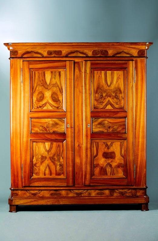 Biedermeierschrank, Badisch um 1830, Nußbaum, 2-türig, Front und Seiten kassettiert, abgerundete Ecken, sehr schönes Furnierbild, org. Füsse und ...