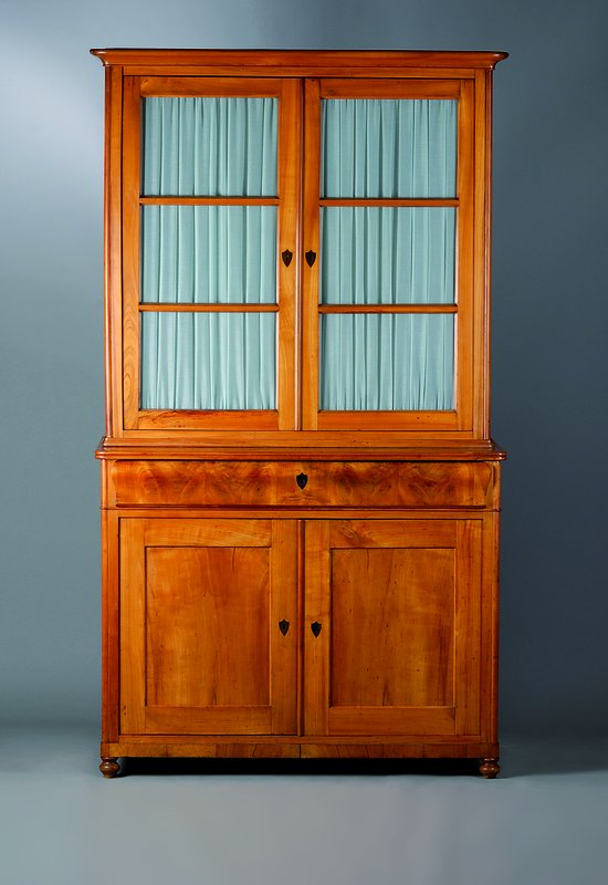 Vitrinenschrank, Biedermeier, um 1830/40, Kirschbaum massiv, Unterteil 2-türig, 1-schübig, Oberteil 2-türig verglast u. versprosst, eine Scheibe ...