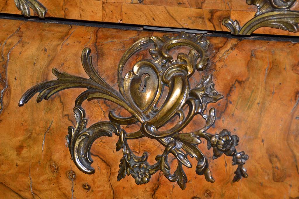Detail a: Kommode, Italien, um 1750, Wurzelnußfurnier vielfach gesp. verlegt, aufwendige Bronzebeschläge m. alter Vergoldung, 3-schübig, Furnierteile teils ...