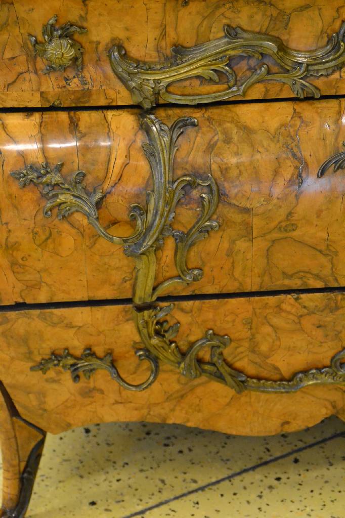 Detail i: Kommode, Italien, um 1750, Wurzelnußfurnier vielfach gesp. verlegt, aufwendige Bronzebeschläge m. alter Vergoldung, 3-schübig, Furnierteile teils ...
