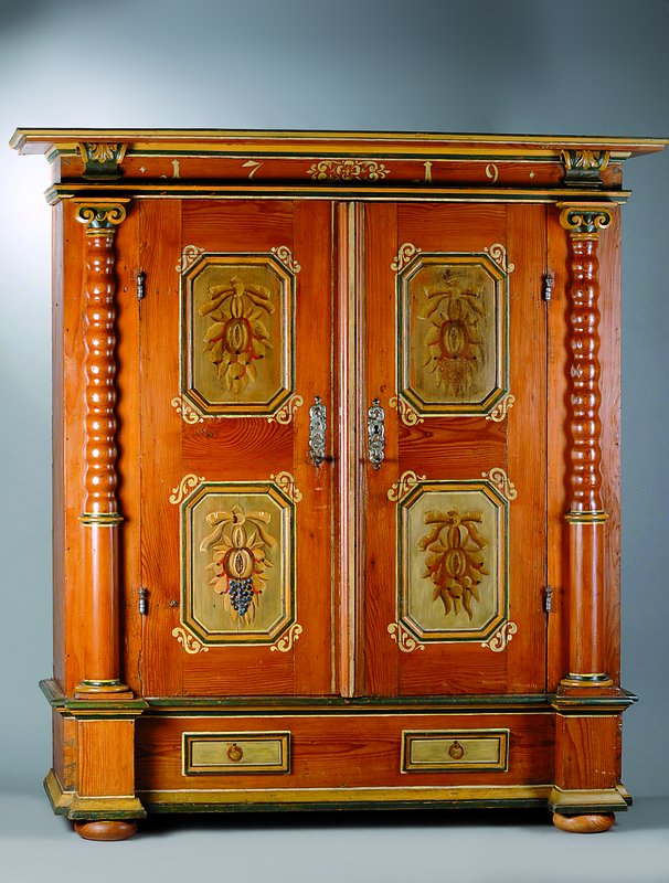 Barockschrank, dat. 1719, Weichholz, bunt bemalt, 2-türig, Inlets getreppt m. reicher Bemalung in Form v. Obst, Lisenen mit Halbsäulen, Kopf ...