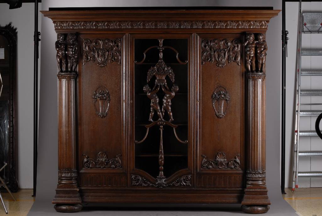 Bücherschrank, deutsch, um 1910, Eiche massiv, aufwendige Schnitzereien, Lisenen mit vollplastischen Putti, Kopf vielfach getreppt,3-türig, 1 Tür ...