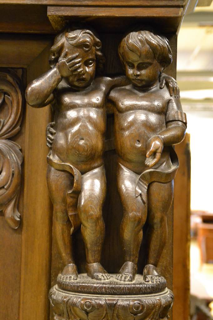 Detail a: Bücherschrank, deutsch, um 1910, Eiche massiv, aufwendige Schnitzereien, Lisenen mit vollplastischen Putti, Kopf vielfach getreppt,3-türig, 1 Tür ...