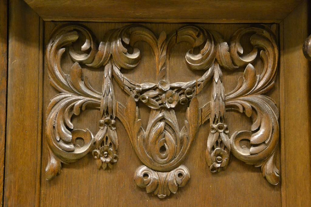 Detail d: Bücherschrank, deutsch, um 1910, Eiche massiv, aufwendige Schnitzereien, Lisenen mit vollplastischen Putti, Kopf vielfach getreppt,3-türig, 1 Tür ...