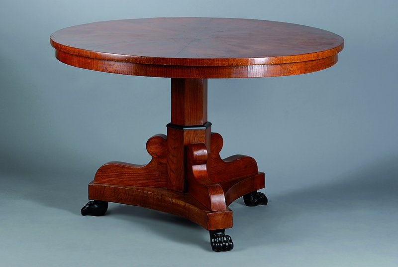 Runder Biedermeiertisch, um 1820/30, Nußbaum, vielfach gespiegelt verlegt, Platte mittig mit Brandmalerei, Tatzenfüße, schwundrissig, l. ...