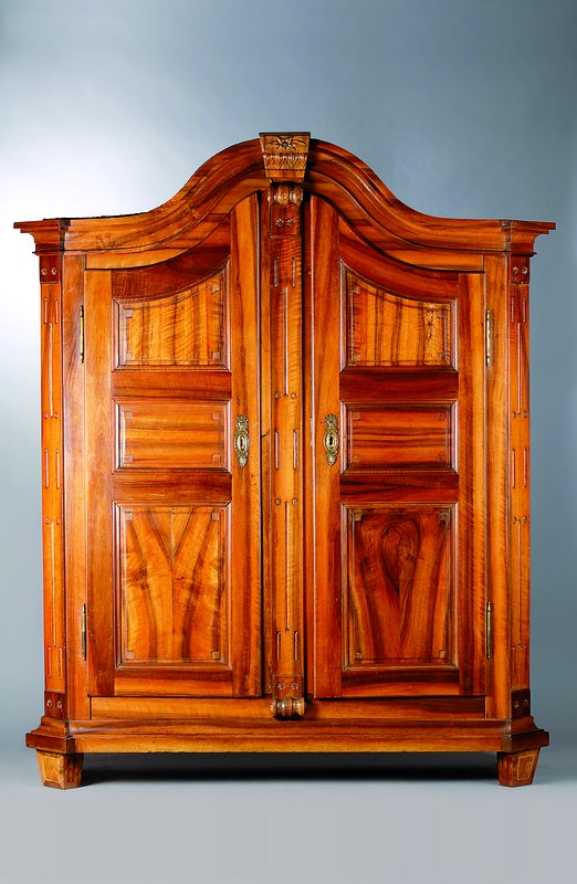 Schrank, wohl Landau um 1780/1800, Nußbaum, 2-türig, 12-fach kassettiert, abgeflachte Ecken, Inlets getreppt, Kopf m. Voluten und ...