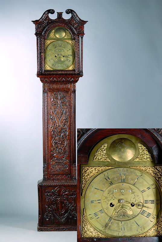 Standuhr, England um 1800, reich verziertes und geschnitztes Holzgehäuse, Füße und kl. Bekrönung fehlen, Messingbogenzifferblatt (urspr. nicht zu ...