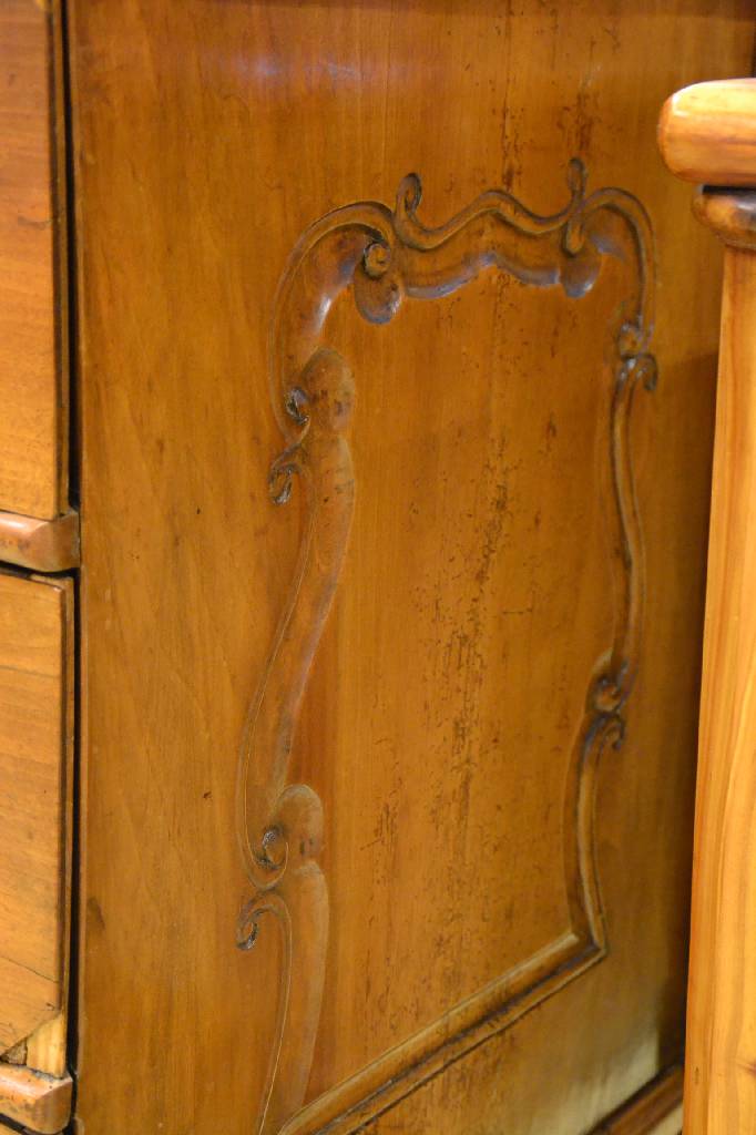 Detail a: Barockkommode, um 1750/60, Nußbaum, 3 -schübig, Seiten und Schürze mit Volutenschnitzerei, Front geschweift, orig. Schlösser, Ergänzungen, Reste ...