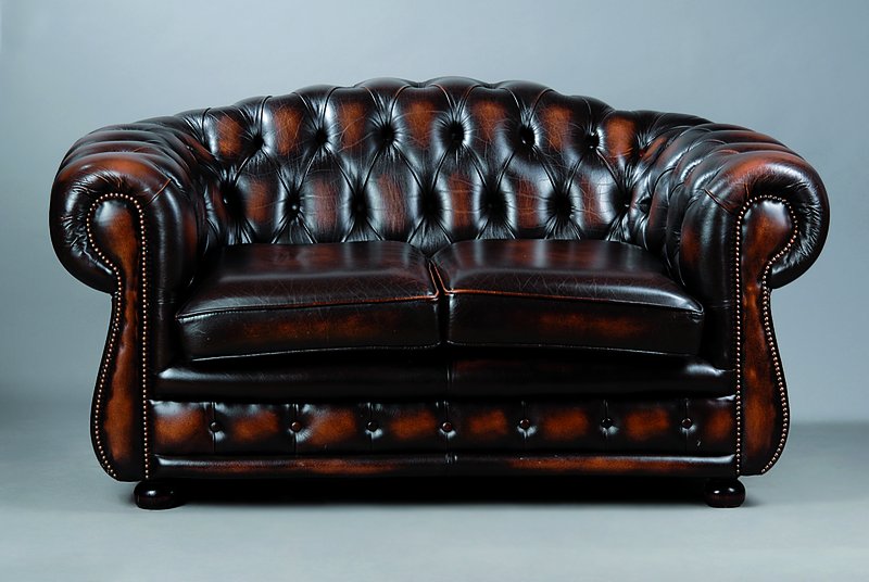 Chesterfield Sofa, nach englischem Vorbild, 20. Jh., 2-Sitzer, braunes Kunstleder, lose Sitzkissen, geheftet und genoppt, st. Gebr.- Sp., ca. ...