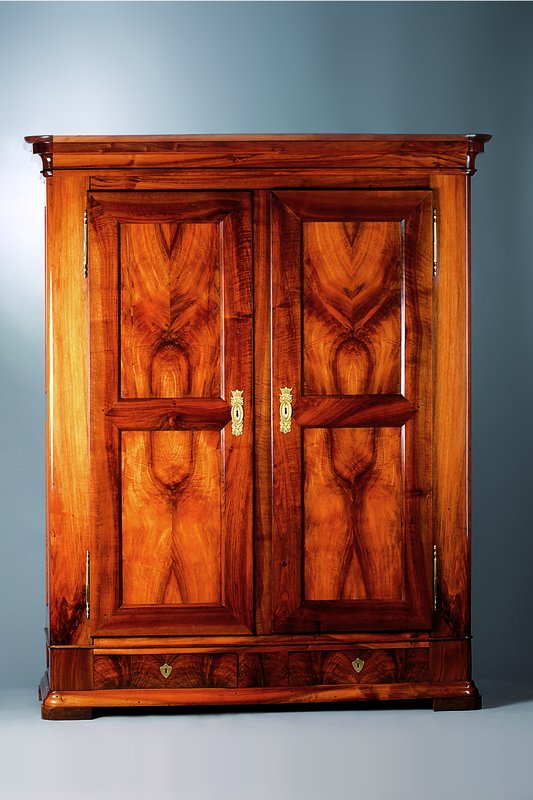 Biedermeierschrank, Baden um 1830, Nussbaum massiv, z.T. 4-fach gespiegelt verlegt, Rahmen in Wurzel-Nuss dazugestaltet, 2 integ. Schubladen, 6-fach ...