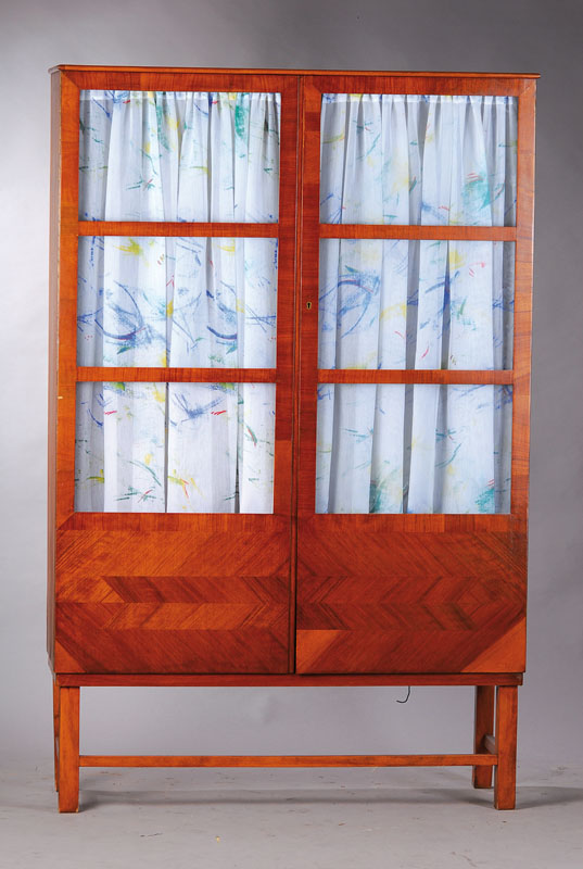 Vitrine, um 1930, Wurzelnussfurnier in Grätenform gespiegelt verlegt, versproßte Beine, praktische Inneneinteilung, verdeutlicht Übergang zwischen ...