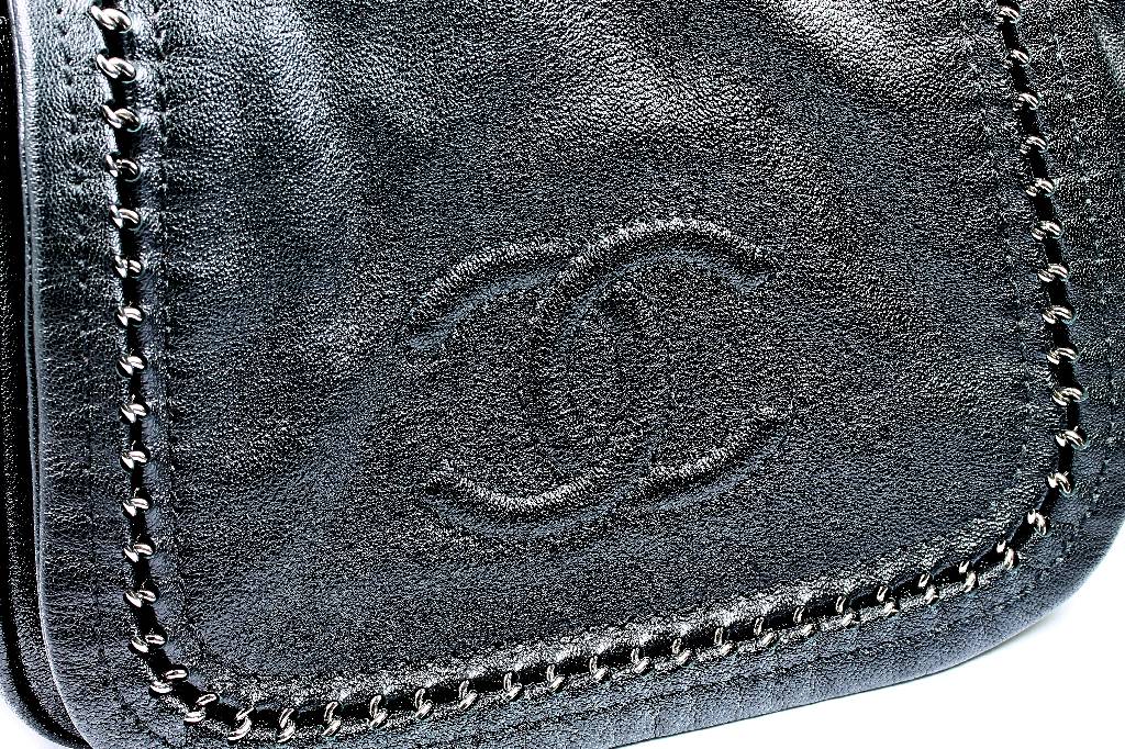 Detail a: CHANEL-Handtasche, schwarzes Leder, Frontklappe mit abgestepptem CC-Zeichen Rändermit Chromkette durchwirkt, Schulterriemen Metall, ...