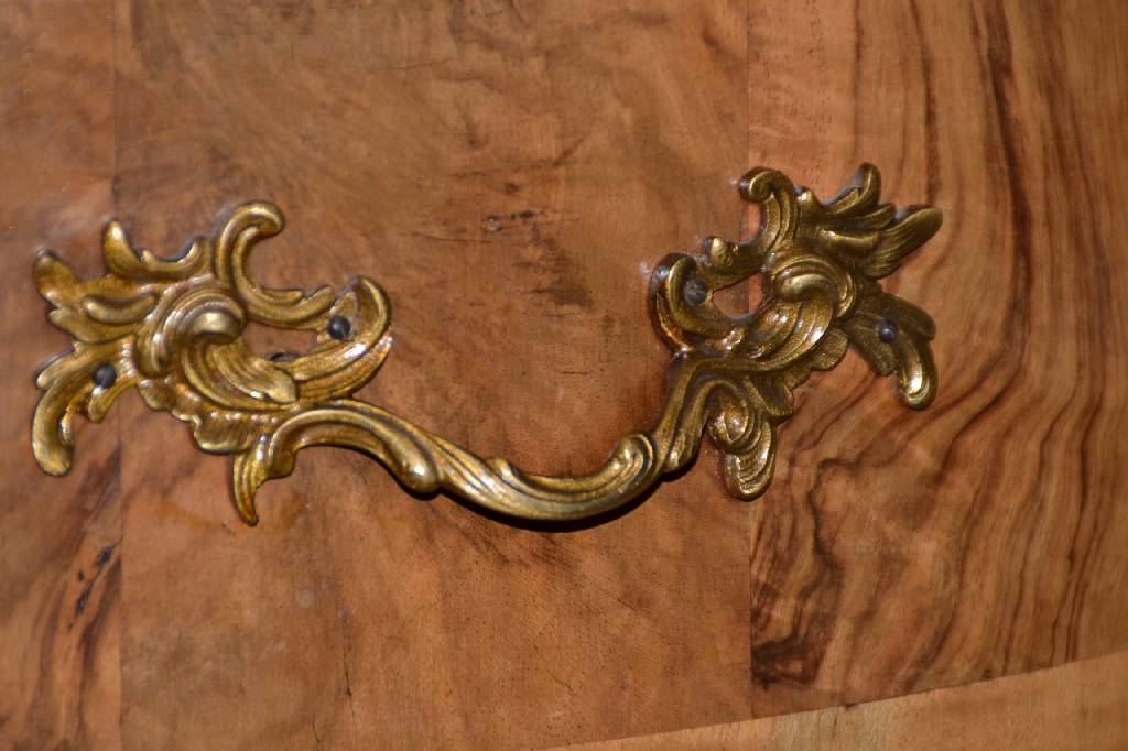 Detail b: Barockkommode, deutsch um 1750, Wurzelnussfurnier, Nussholz quer angeleimt, 3 -fach geschweift und doppelt gekröpft, 3- schübig, Beschläge sek., ...