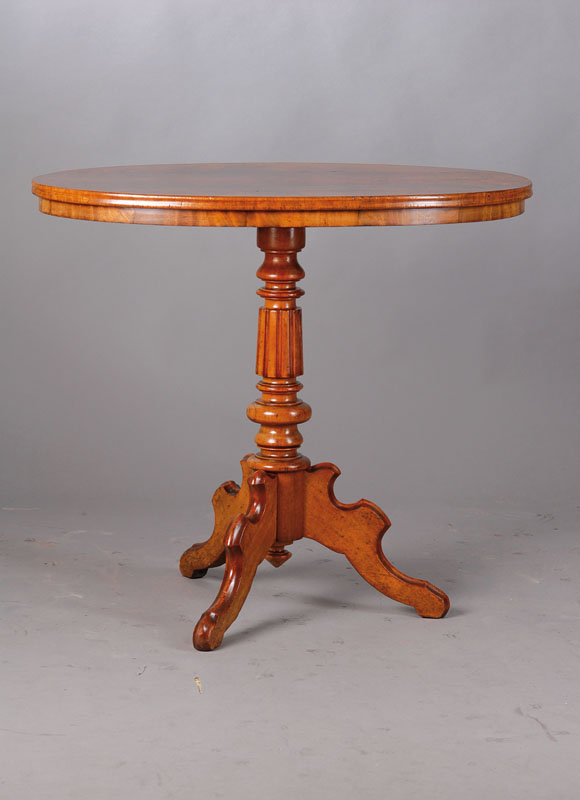 Ovaler Tisch, um 1860/70, Pyramidenmahagoni,reich gedrechselte Säule, stehend auf 3 geschweiften Tischbeinen, seltene kleine Form,ca. 74x85x54 cm