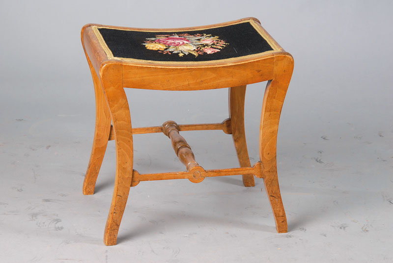 Hocker, deutsch, um 1820-30, Biedermeier, Nußbaum, Bezug bestickt, fein gedrechselter Steg, lt. in sich gebogte Form, ca. 44x46x35 cm