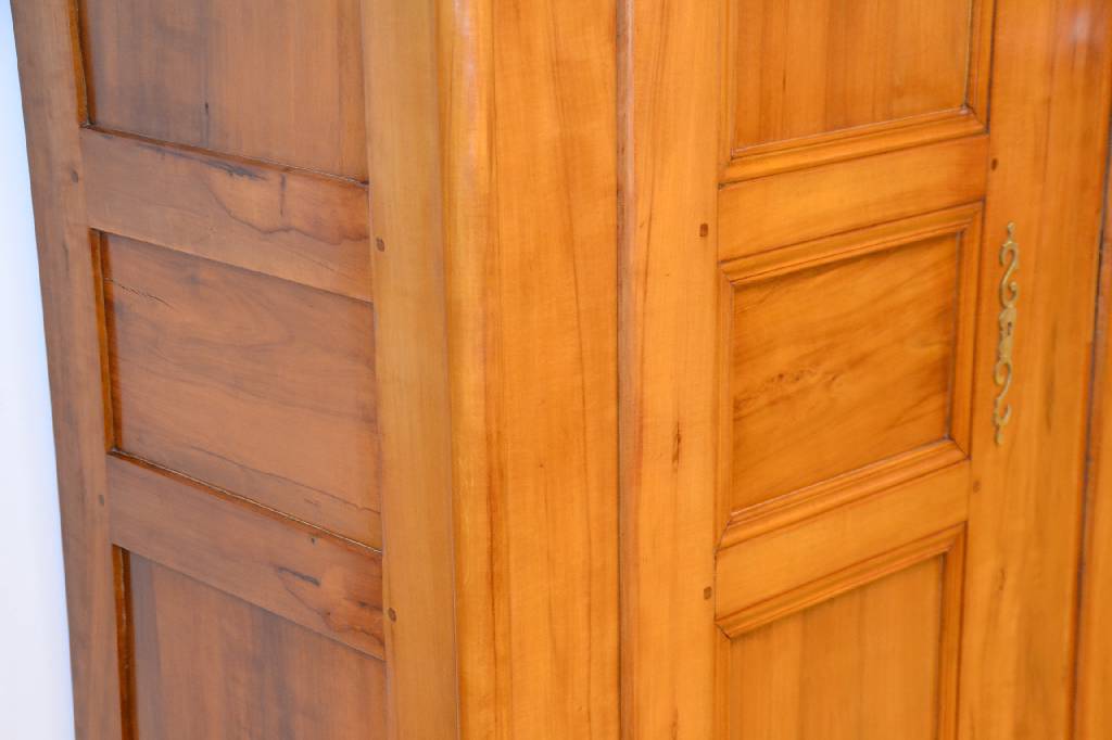 Detail b: Louis-Seize-Schrank, Pfalz/Elsaß, ausgehendes 18. Jh., Birnen-/Kirschholz, Kopf 4-fach getreppt mit Hohlkehle, Türen u. Seiten je 3- fach mit ...