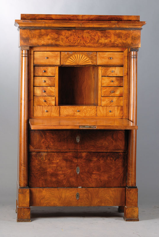 Standsekretär, norddeutsch um 1830, Wurzelnussfurnier doppelt u. 4-fach gespiegelt verlegt, 4-schübig, Kopf 3-fach getreppt, Fuß passig, seitliche ...