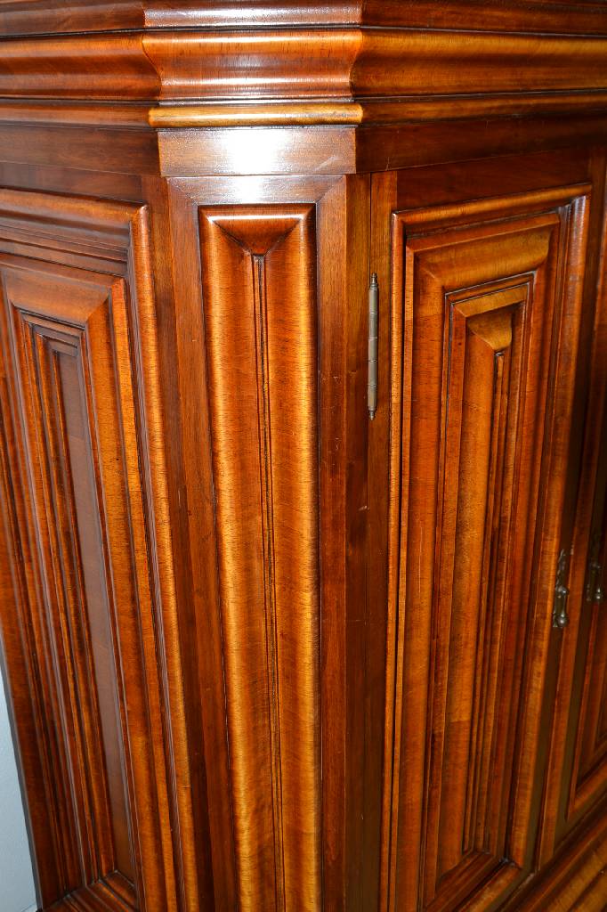 Detail a: kleiner Wellenschrank, Italien, um 1970, Nussbaum massiv z.T. quer furniert, Kopf vielfach getreppt mit Hohlkehle u. S-förmigem Profil, Türen je ...