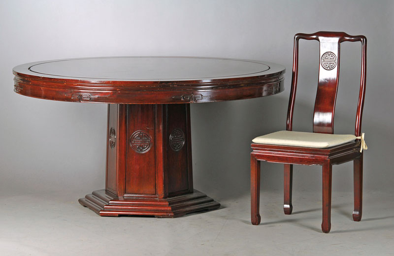 Tisch und 6 Stühle, China, 20. Jh., Mahagoni, Zarge u. Lehne profiliert mit aufgesetzten Schnitzereien, Stühle mit Sitzkissen, Geb.-Sp., schwere ...