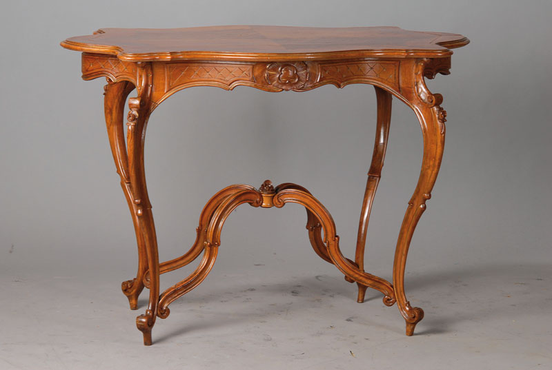 Tisch, um 1860, Nussbaum massiv u. z.T. doppelt gespiegelt furniert, Platte vielfach geschweift u. gekröpft, Füße beginnen u. enden in Voluten, ...