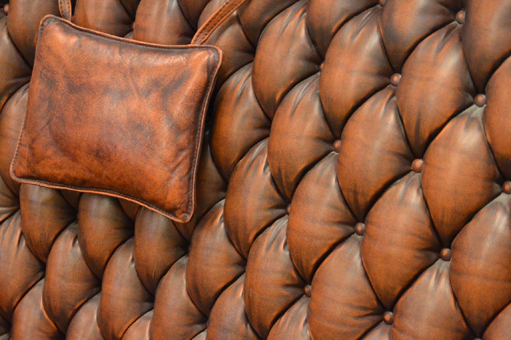 Detail b: Sofa und zwei Sessel, Chesterfield, 2. Hälfte 20. Jh., Je mit Ohrenbacken, Lehnen vielfachgenoppt, Kissen aufwendig gebordet, Leder festgenagelt, ...