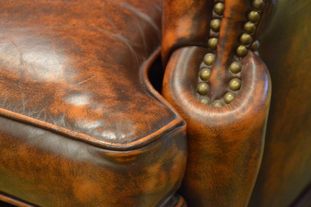 Detail c: Sofa und zwei Sessel, Chesterfield, 2. Hälfte 20. Jh., Je mit Ohrenbacken, Lehnen vielfachgenoppt, Kissen aufwendig gebordet, Leder festgenagelt, ...