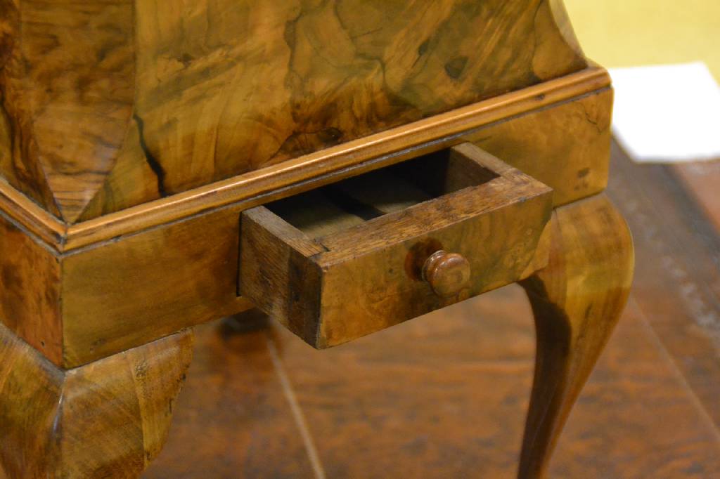 Detail a: Blumenhocker, deutsch, um 1900/10, Nußbaumfurnier, mit Metalleinsatz, obere Kanten abgeplattet, geschweifte Füße, 1- schübig, ca. 45x31x31 cm