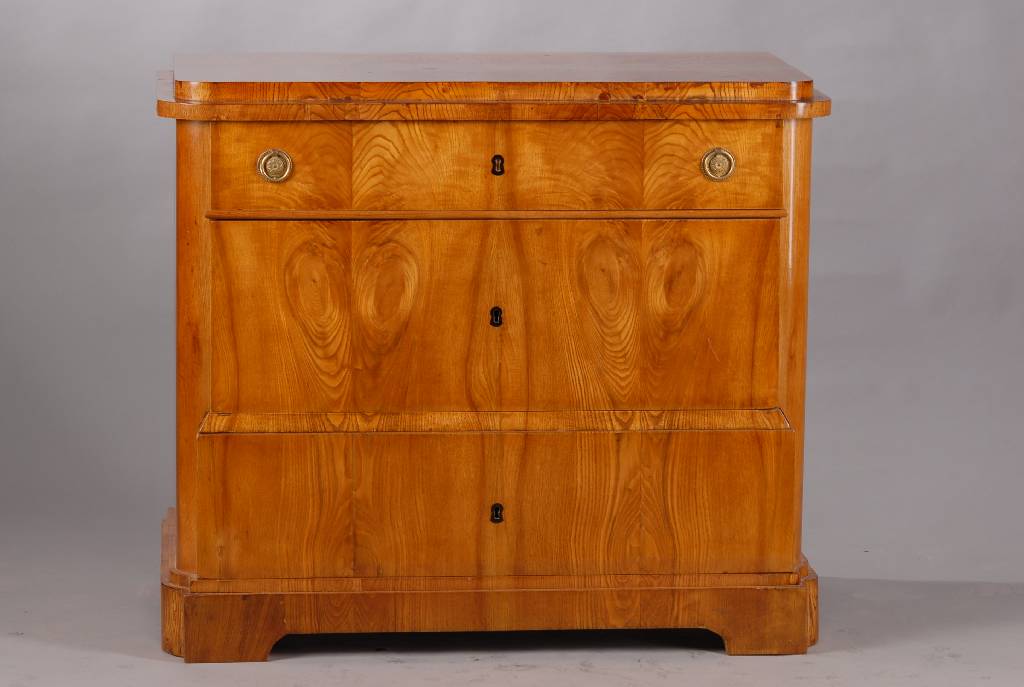 Kommode, um 1830, Eschefurnier doppelt gespiegelt verlegt, Platte abgekantet, 3- schübig, unterer Schub u. Sockel lt. ausladend, restauriert, ...