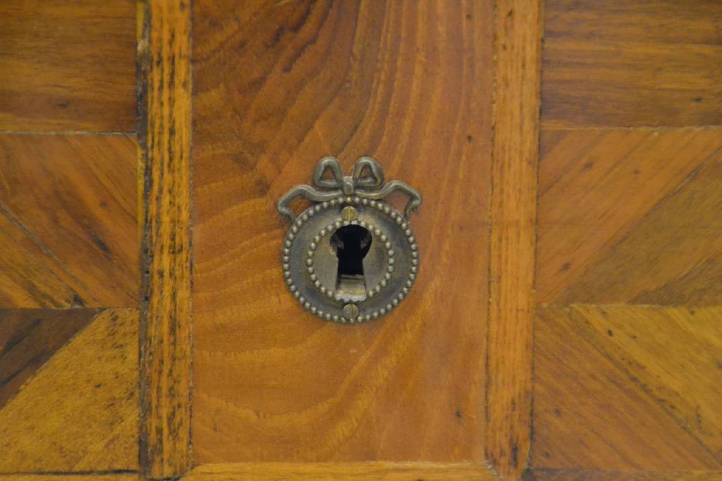 Detail b: Kommode, wohl Portugal um 1900, 4-schübig, unter Verwendung von Teilen aus dem 18. Jh., Korpus Weichholz, Nußbaumfurnier, geometrischeIntarsien in ...