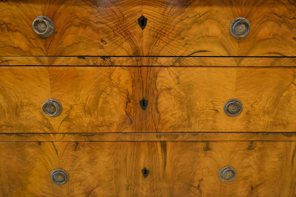 Detail c: Kommode, frühes 19. Jh., Nußbaumfurnier, Plattenseiten geschwärzt, Front je doppelt gespiegelt, Seiten je gespiegelt verlegt, 3-schübig, ...