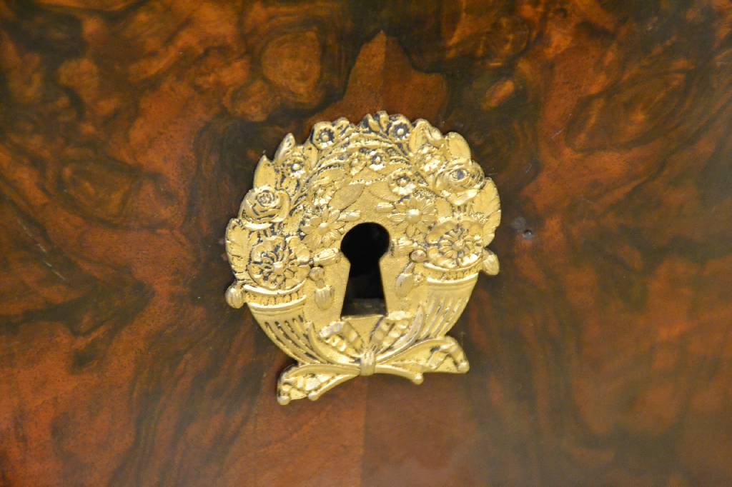 Detail a: Kommode, Frankreich um 1800/15, Empire, Nussbaumkorpus, Front 4-fach gespiegeltes Wurzelnussfurnier verlegt, 4-schübig, seitl. sich verjüngende ...