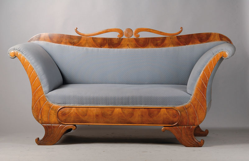 Biedermeiersofa, wohl Mainz um 1830, Volutenbekrönung, Rückenlehne l. geschweift, ausladende Armlehnen, typisches Füllhornmotiv,gerieft, Bezug u. ...