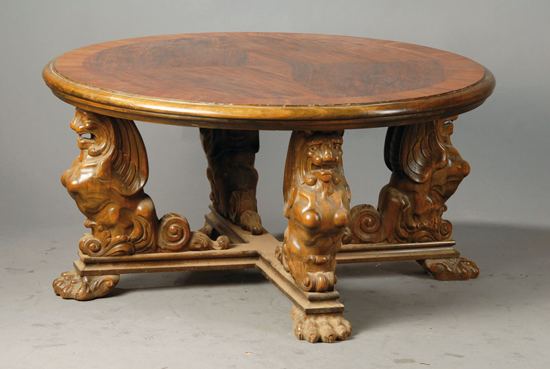 Sofatisch, deutsch um 1920/30, Platte mit abgerundeter Kante, Nussbaumfurnier doppelt gespiegelt verlegt, Kreuzsteg mit plastischen Löwenstützen, ...