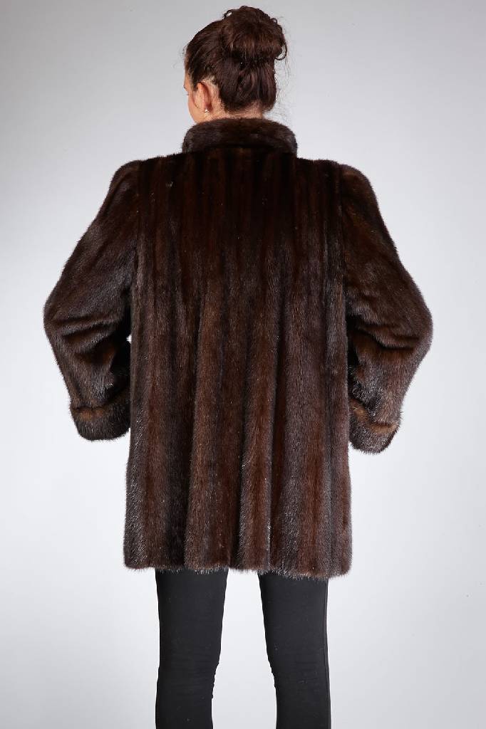 Detail a: Nerzlongjacke, Gr. ca. 38, braune Felle längs verarbeitet, Stehkragen mit Zierknopf, Ärmel mit Manschetten, 2 seitl. Einschubtaschen, schwarzes ...