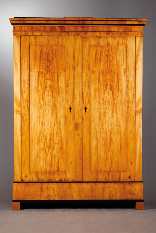 Biedermeierschrank, wohl Bayern um 1830, Ahornfurnier auf Weichholzkorpus, geschwärzte Profilleisten am Kopf sowie geschwärzte, stilübliche ...