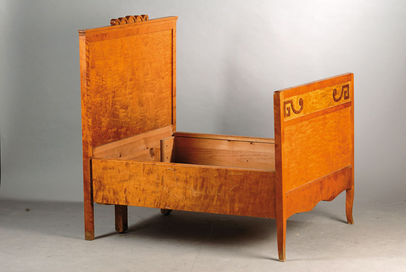 Ausziehbett, deutsch um 1905/06, Birkefurnier auf Weichholzkorpus, Kopf- u. Fußteil je kassettiert, aufgesetzte abstrakte Schnitzerei, geschweift ...