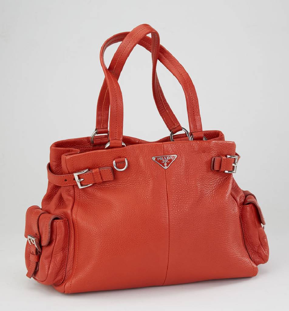 PRADA Handtasche, Leder in rostrot, 2 Tragehenkel, seitl. aufgesetzte Taschen mit Schnallenapplikationen, Prada Milano Emblem, innen schwarzer Stoff ...