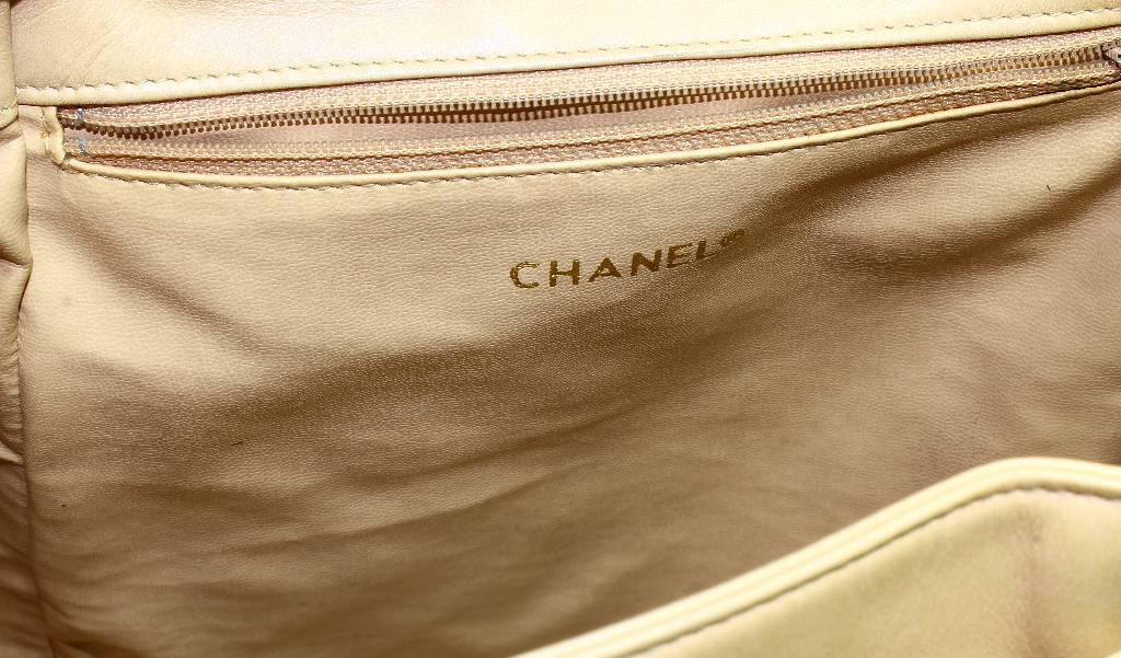 Detail b: CHANEL Rucksack, beiges Leder, gesteppt, Chanel Emblem verg., Trageriemen z.T. mit Kette, Innentasche mit Reißverschluss, Zugband, l. Gebr.-Spuren ...