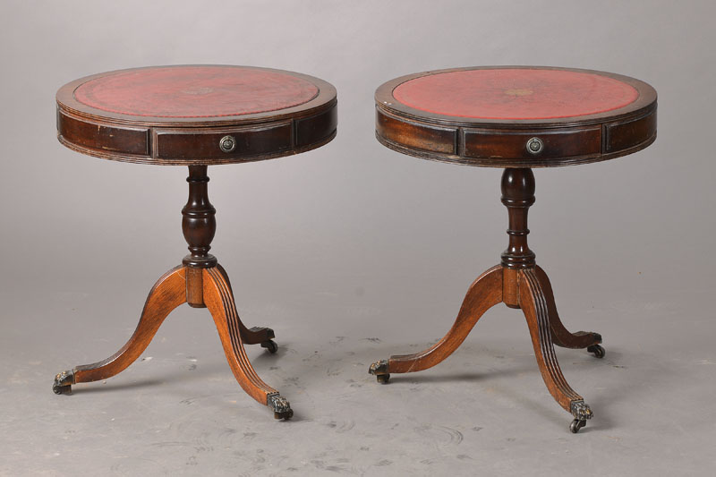 Zwei Beistelltische, sog. Drum Table, England,20. Jh., Mahagoni, je mit drei Schubladen, Lederplatten, sehr dekorativ, Gebr.-Sp., rest., je ca. D. 50 ...