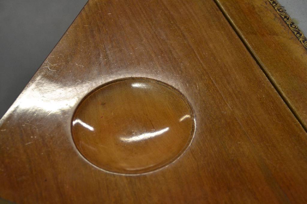 Detail b: Spieltisch, deutsch um 1880/90, Nussbaum furniert, Platte drehbar u. 4-fach aufklappbar, beschnitzte Mulden für Spielsteine, Balustersäulen mit ...