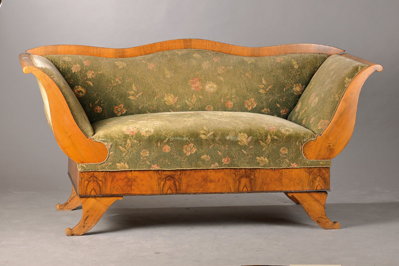 Biedermeiersofa, südwestdeutsch um 1830, Nussbaum gespiegelt verlegt, Lehne geschweift, Armlehne weit ausladend, Beine füllhornförmig, Reste alten ...