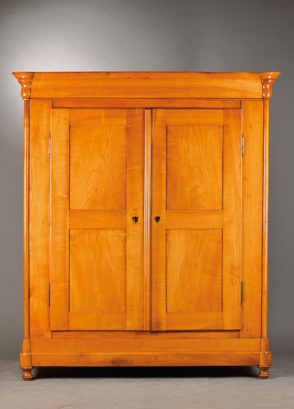 Biedermeierschrank, wohl Niedersachsen um 1835/40, Kirschbaum massiv, z.T. gespiegelt,Türen u. Seiten je doppelt kassettiert, Ecken mit angesetzten ...